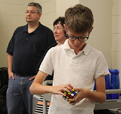 Fifth-grader Sam Viglione attempts to solve the Rubik's Cube.