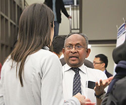chandra speaking with a graduate student at a poster fair
