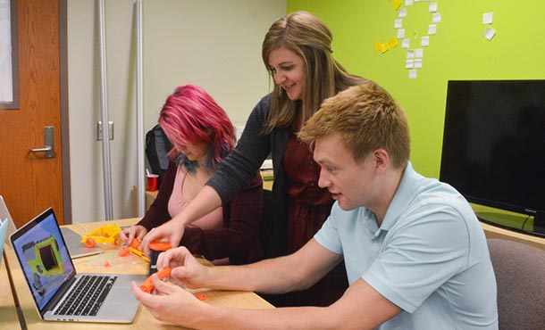 Scarlett Miller, Elizabeth Starkey and Clayton Meisel discuss an assignment