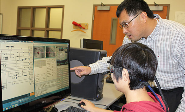 Ling Rothrock prepares an eye tracker for assessing a Piping and Instrumentation Diagram with Jingwen Li, a graduate student in industrial engineering.