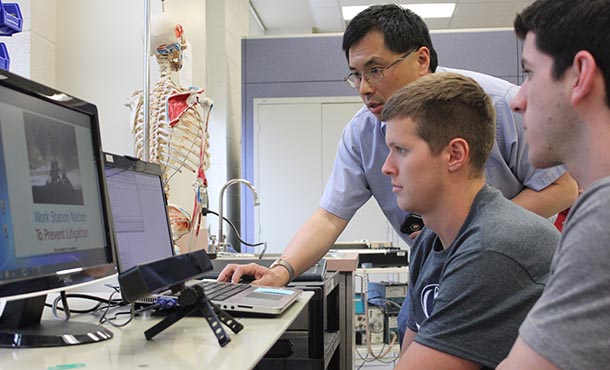 Ling Rothrock assists students in his classroom