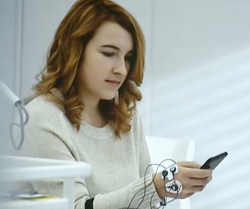 A girl uses a smartphone with sensors on to test usability