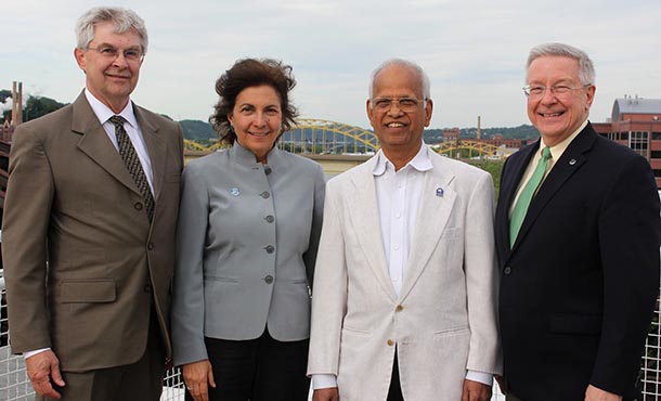 Robert Voigt, A. "Ravi" Ravindran and Russell Barton with Janis Terpenny, department head with the Pittsburgh skyline in the background