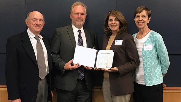 Four members of the PSIMES Board of Directors holding the Membership Award