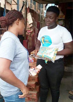 L&L Foods workers pass out peanuts to Nigerians.