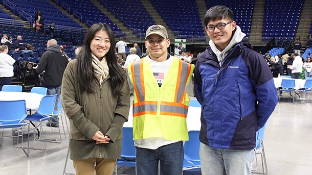 Walmart representative posing with two industrial engineering graduate students at the Military Appreciation Tailgate.