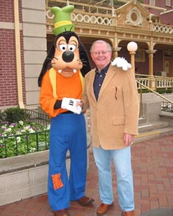 jim benedick poses with goofy at disneyland